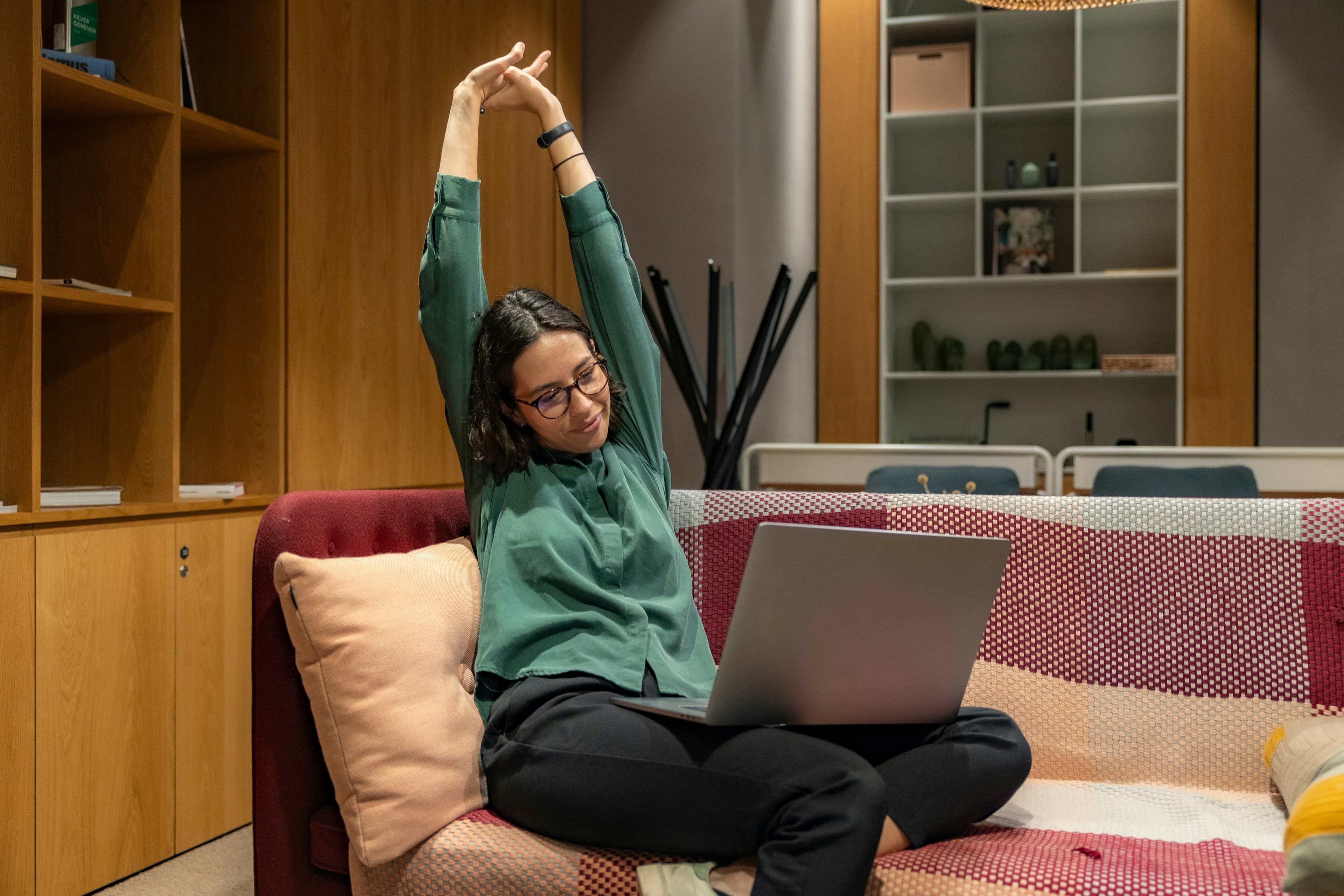 A woman relaxing on a sofa with a laptop, demonstrating the comfortable self-paced assessment experience